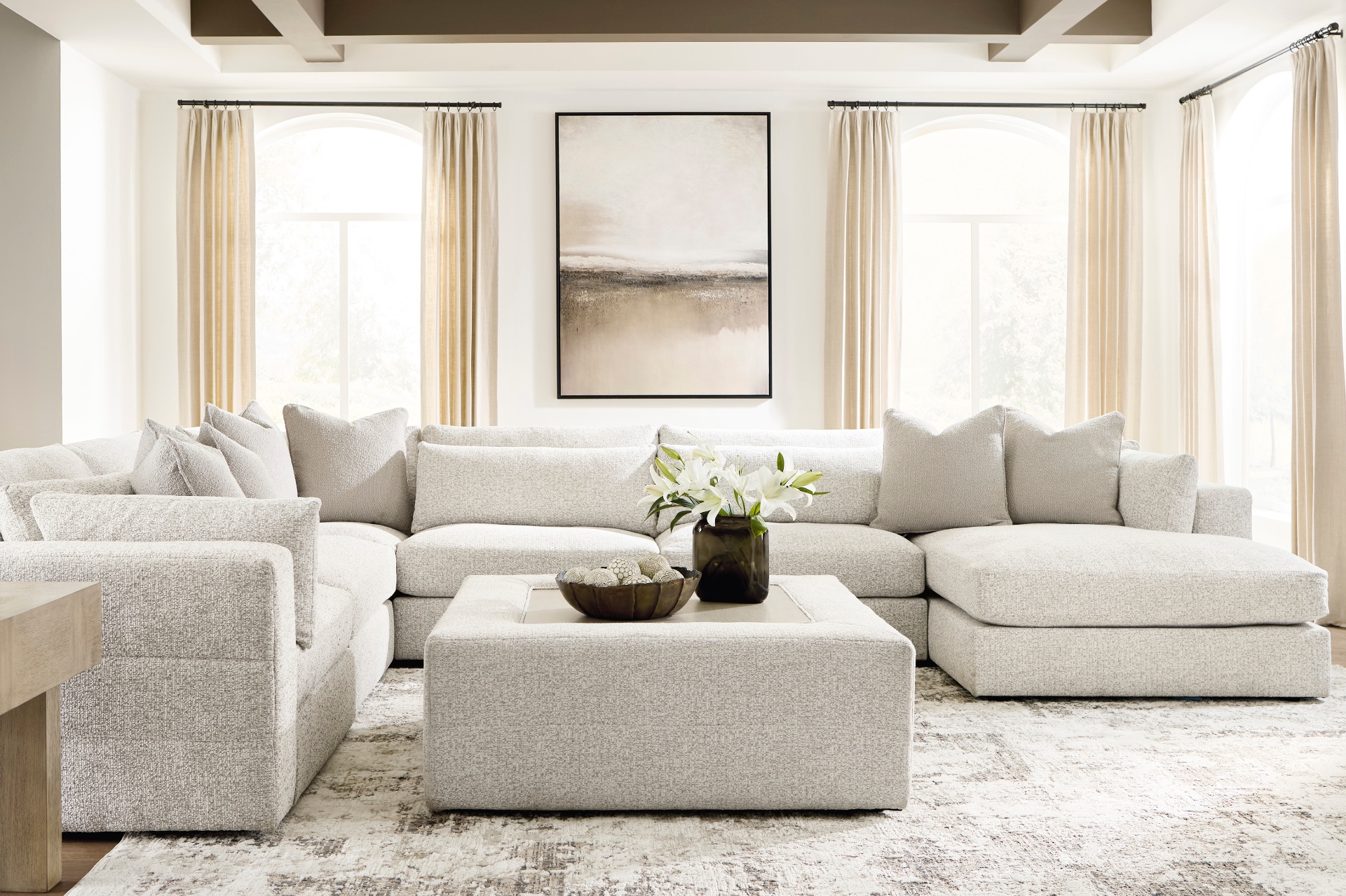 Cream boucle sectional in a bright, airy living room with arched windows and linen drapery